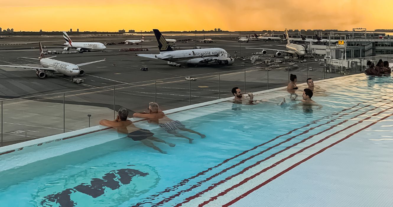 uma piscina no telhado do aeroporto jfk com vista para a pista