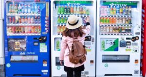 a woman using a vending machine in japan