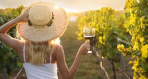 Young woman with glass of wine in vineyard