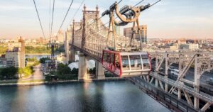 the roosevelt island tramway in nyc over the east river at sunset