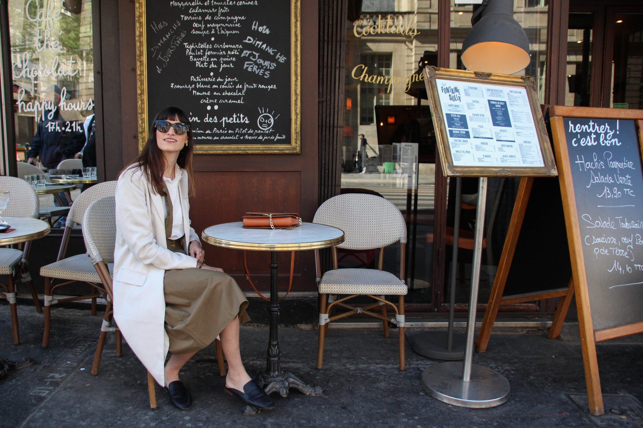 Mulher sentada em uma mesa de café em Paris, França