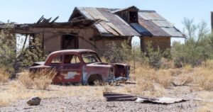 a car and dilapidated house in the abandoned ghost town of vulture city, arizona
