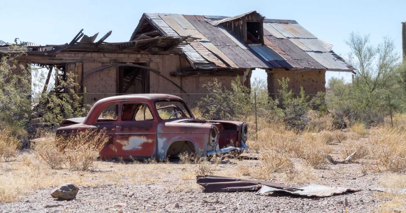 um carro e uma casa em ruínas na cidade fantasma abandonada de vulture city, arizona
